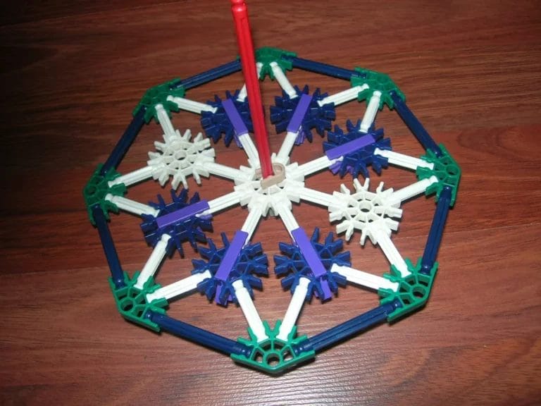 If you played spinning Jacks as a kid you must watch it swirl around for a long time. Here’s a classic from the game of Jacks, that actually spins. Bigger, better spins faster, and built out of K'nex!! It has a good amount of 58 total parts, including: 6 purple connectors 6 blue connectors 3 white connectors 8 green connectors 8 blue rods 24 white rods 1 red rod 1 gray pinned connector 1 brown end cap with the rod coming out of it Get the complete instructions to spin around your DIY K’NEX Jacks! 2. K’NEX Basketball Game